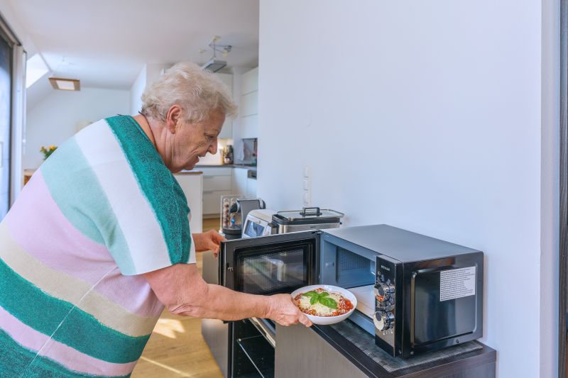 Oma stellt Essen in die sprechende Mikrowelle