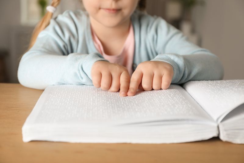 Kinderhände lesen einen Brailletext
