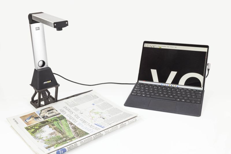 ZEN MAX attached to a laptop capturing a newspaper_web