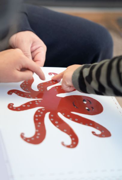 Kinderhände greifen Oktopus-Bild an