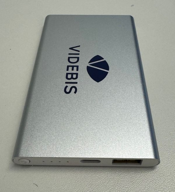 eine silberne Powerbank mit blauem VIDEBIS Logo