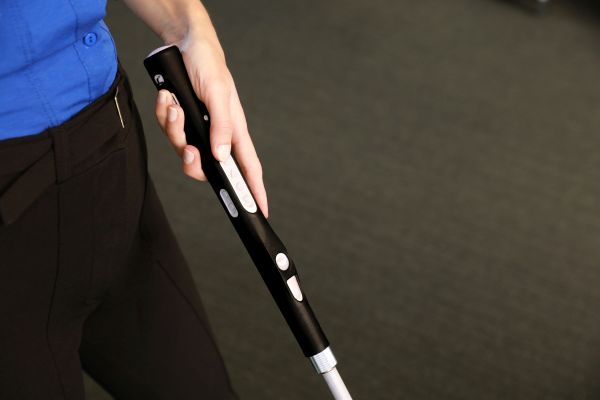 Dame mit WeWalk SmartCane 2 beim Drücken der Tasten