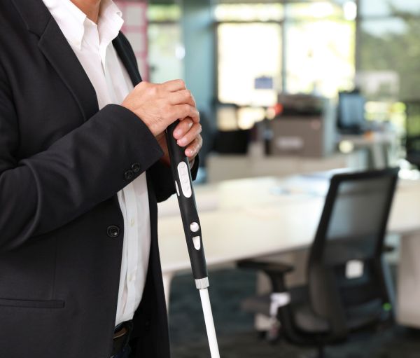 Herr mit WeWalk SmartCane 2 im Büro