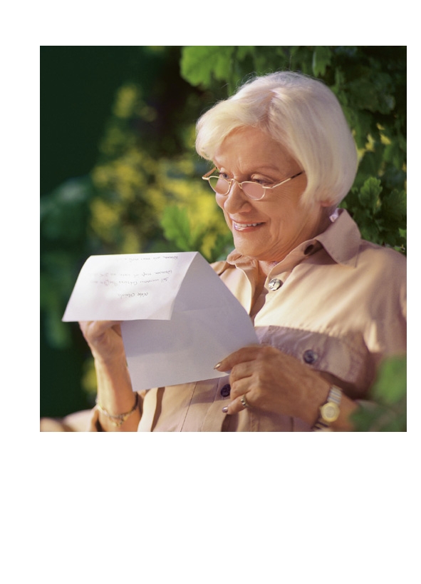 Ältere Dame liest einen Brief mit einer binokularen Lupenbrille