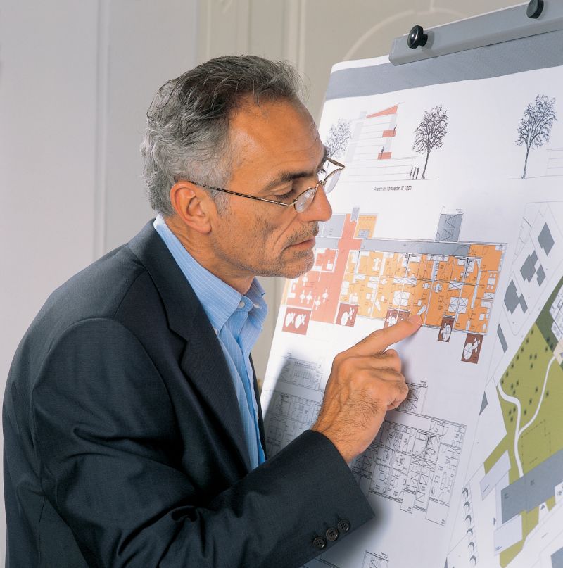 Mann liest einen Plan mithilfe einer binokularen Lupenbrille