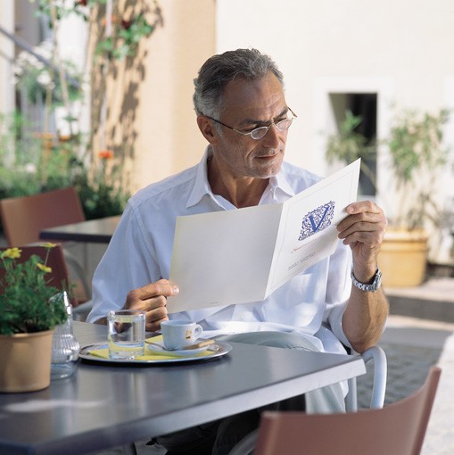 Produktfoto Herr liest Zeitung mit einer monokularen Lupenbrille