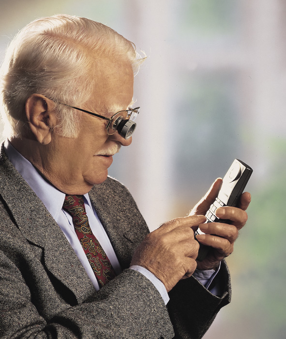 Mann tippt mit einer Fernrohrbrille am Telefon